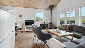 Uma sala de estar moderna com lareira, um sofá, uma mesa de centro e uma televisão.