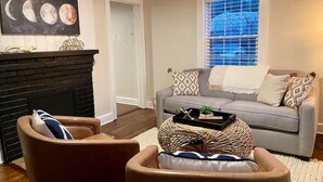 Un salon avec une cheminée, un canapé gris et une table basse.