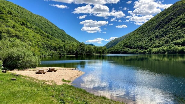 A serene lakeside setting with picnic tables and a clear view of the surrounding lush green hills. - La Villa Del Lago (Valganna)