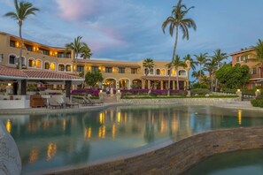 Relax by the pool surrounded by lush greenery and arches.