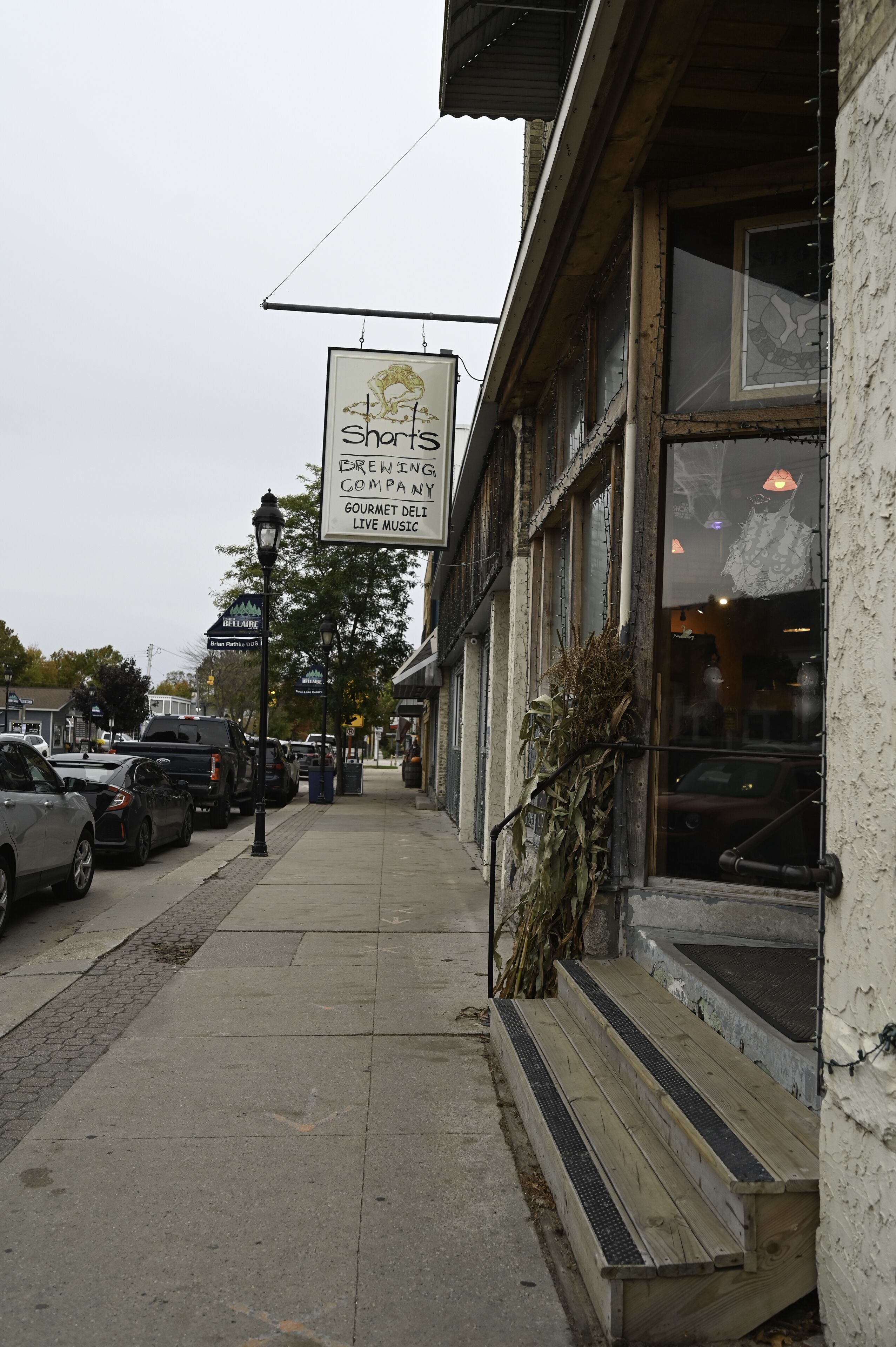 Una vista di strada con un ristorante chiamato 'Shorts Brewing Company' e un cartello che indica 'Beef & Cheese'.