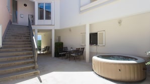 A spacious outdoor area with a hot tub, a dining table with chairs, and a staircase leading to an upper level. - Awesome apartment in Podgrade with WiFi (Podgrade)