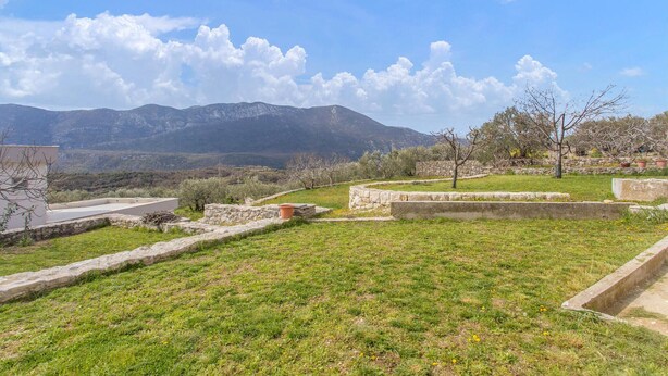 A grassy area with stone walls and a view of mountains in the background. - Awesome apartment in Podgrade with WiFi (Podgrade)