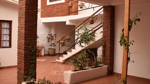 A multi-level courtyard with brick walls, a staircase, and potted plants.