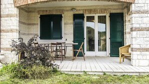 A stone building with a covered porch, green shutters, and outdoor furniture. - S287 - Sirolo, villa with garden near the centre (Sirolo)