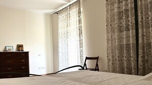 A bedroom with a bed, a dresser, a chair, and curtains. - S287 - Sirolo, villa with garden near the centre (Sirolo)