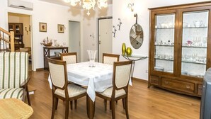 A dining area with a round table, six chairs, a chandelier, a glass cabinet with dishes, and a staircase. - S287 - Sirolo, villa with garden near the centre (Sirolo)