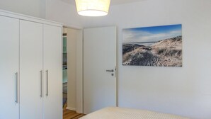 Ein Schlafzimmer mit Bett, Kleiderschrank und einer Tür zum Badezimmer.