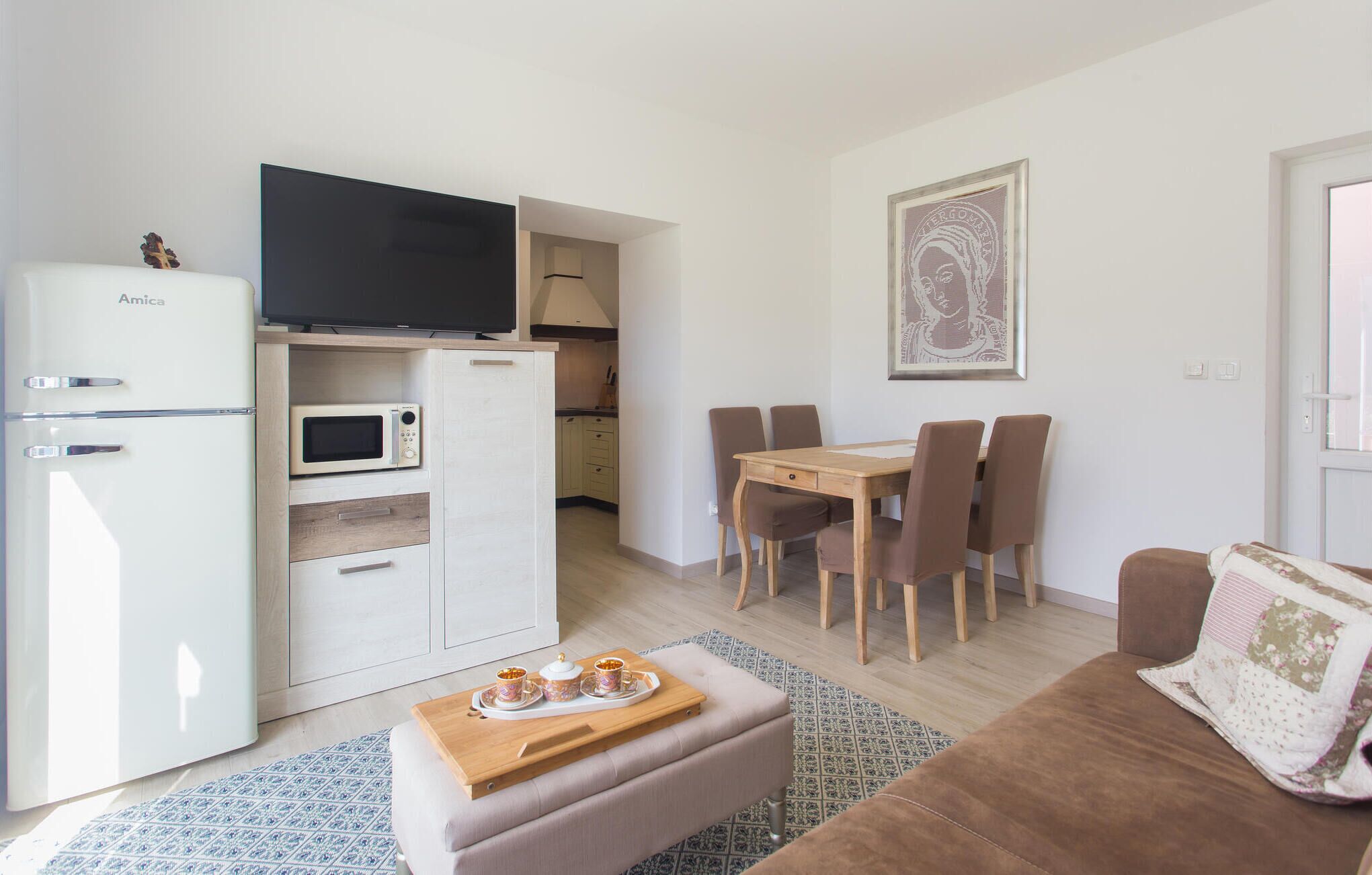 A compact living space with a kitchenette, a dining area, and a seating area.