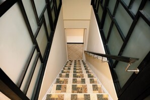 Una escalera con barandilla que conduce a un rellano con una puerta.