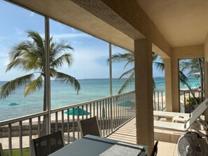 Un balcon avec vue sur l’océan, les palmiers et la plage.