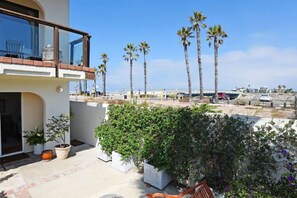 Un balcone con vista su palme e spiaggia.