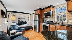 A modern kitchen with stainless steel appliances, wooden cabinets, and a granite countertop. - Cozy Loft for 2- Steps from Village of Pittsford (Pittsford)