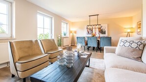 Un salon moderne avec un canapé, une table basse et un coin repas.