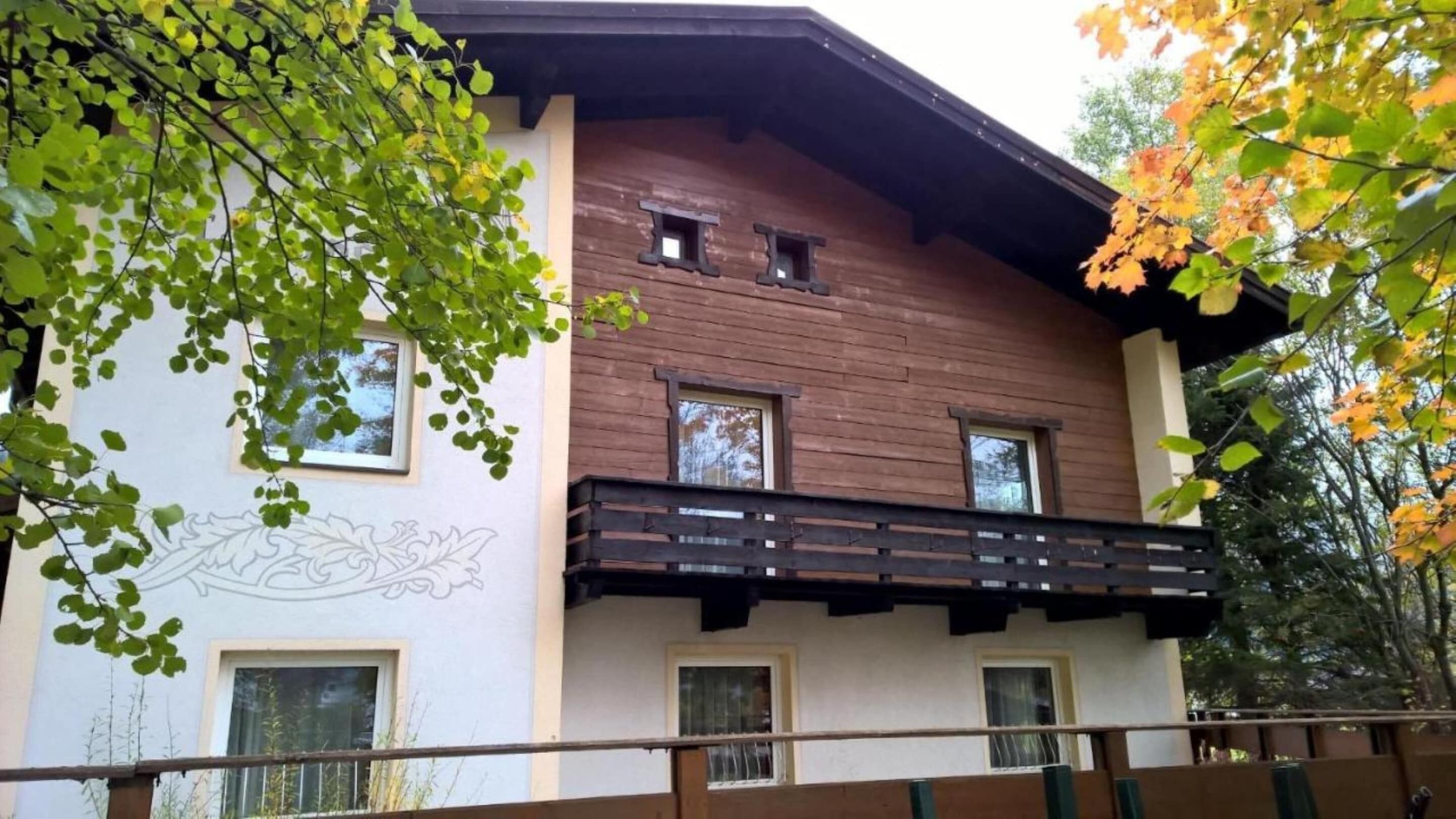 A two-story building with a balcony and multiple windows.