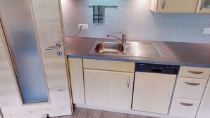 A compact kitchen with a sink, cabinets, and a dishwasher. - Idyllic Apartment in Stumm With Panoramic View (Stumm)