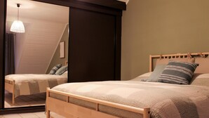 A bedroom with a bed, a mirror, a hanging light fixture, and a dark wall. - Retreat Near Maasmechelen (Lanaken)