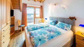 A bedroom with two beds, wooden furniture, a desk, and a chair. - Penthouse Apartment in Wagrain Near ski Area (Wagrain)