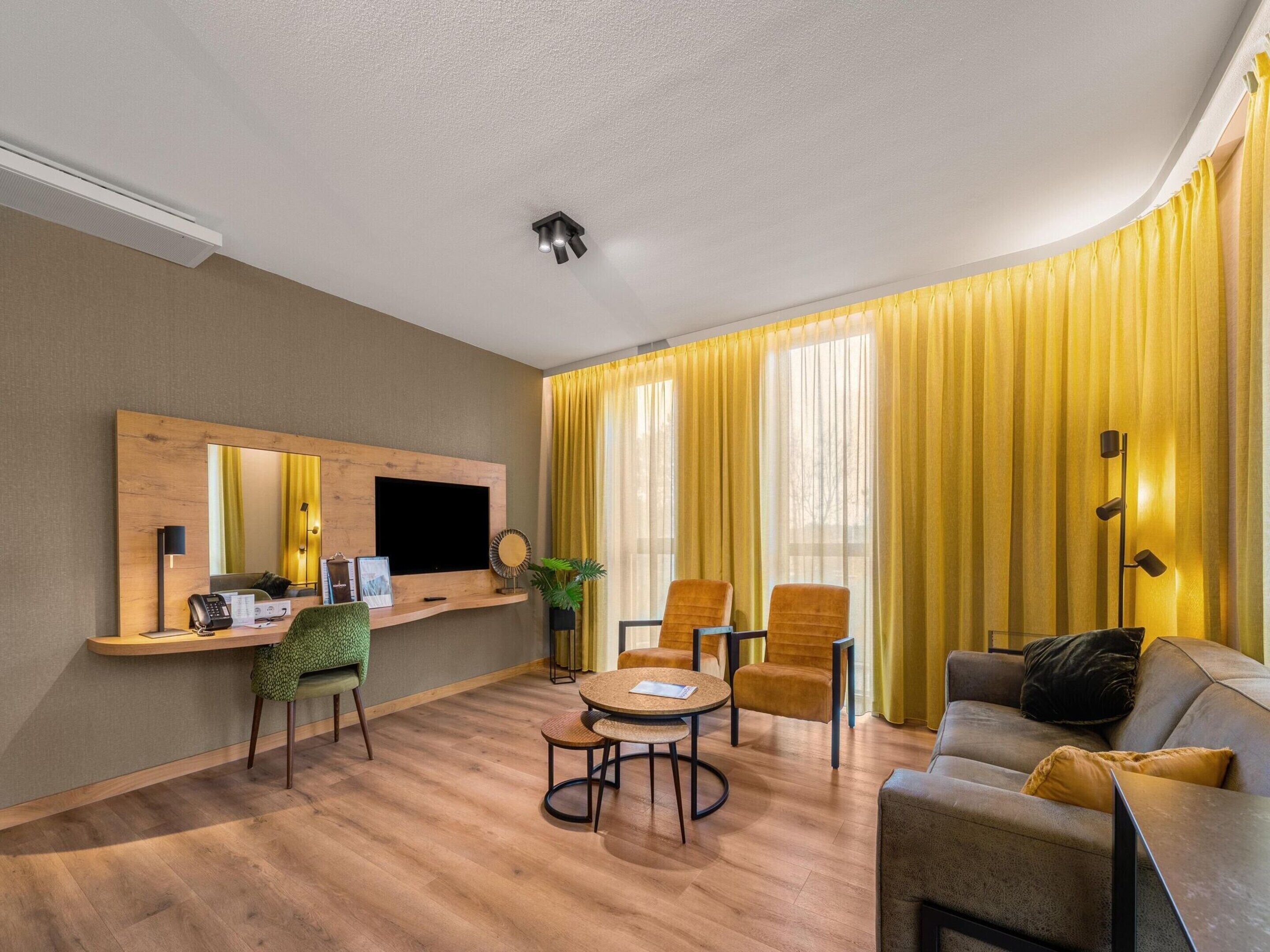 A modern living room with a wooden TV stand, a round table, and two sofas.
