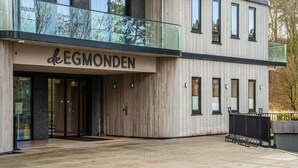 A modern building with a wooden facade and a glass balcony.