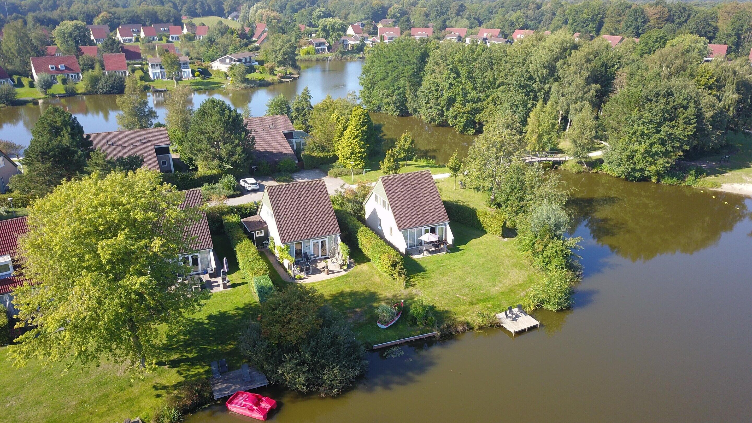 Een woongebied met huizen omringd door water, met een steiger en een boot.