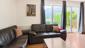 A living room with a sofa, a coffee table, and a painting on the wall. - Fantastic Holiday Home Near Zell am See, Kaprun (Piesendorf)