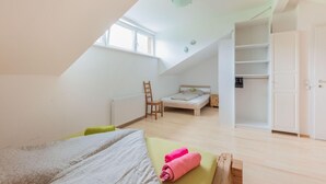 A bedroom with a sloped ceiling, a bed, a chair, a small table, and a wardrobe. - Fantastic Holiday Home Near Zell am See, Kaprun (Piesendorf)