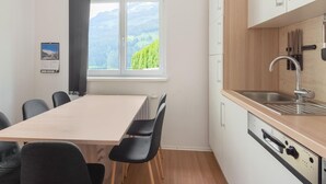 A modern kitchen with a wooden countertop, a stainless steel sink, and a window with a mountain view. - Fantastic Holiday Home Near Zell am See, Kaprun (Piesendorf)