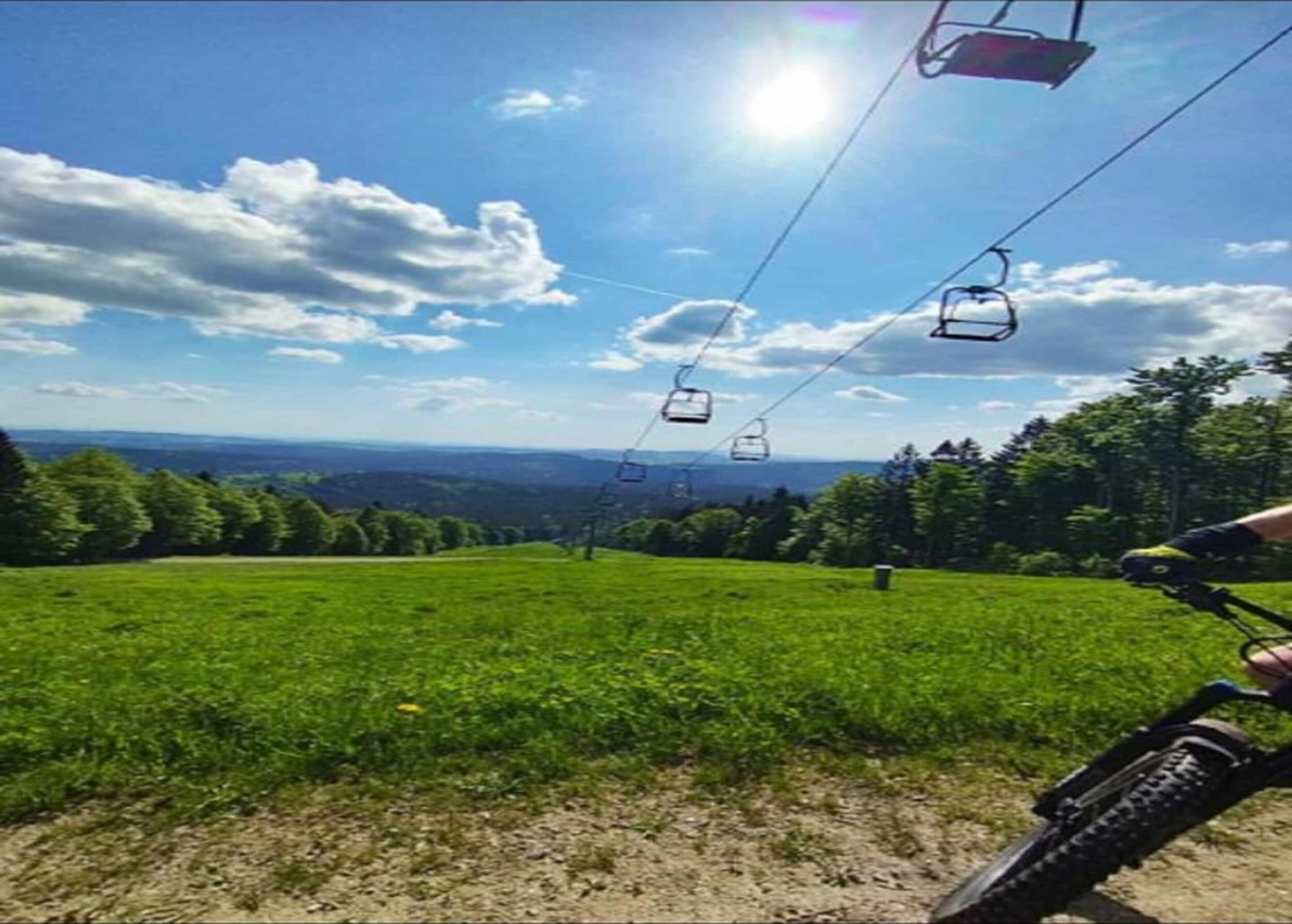 A mountain view with a ski lift and a bicycle in the foreground.