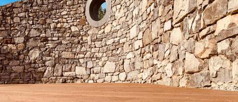 A stone wall with a circular opening.