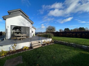 A modern house with a patio, a garage, and a well-maintained lawn.