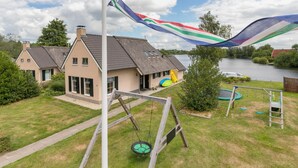 A residential area with houses, a swing set, a trampoline, and a flagpole with a flag.