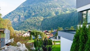 Ein modernes Gebäude mit großen Fenstern und Blick auf eine gebirgige Landschaft.