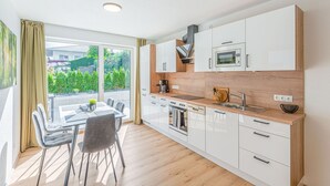 Eine moderne Küche mit weißen Schränken, einer Holz Arbeitsplatte und einem eingebauten Backofen.