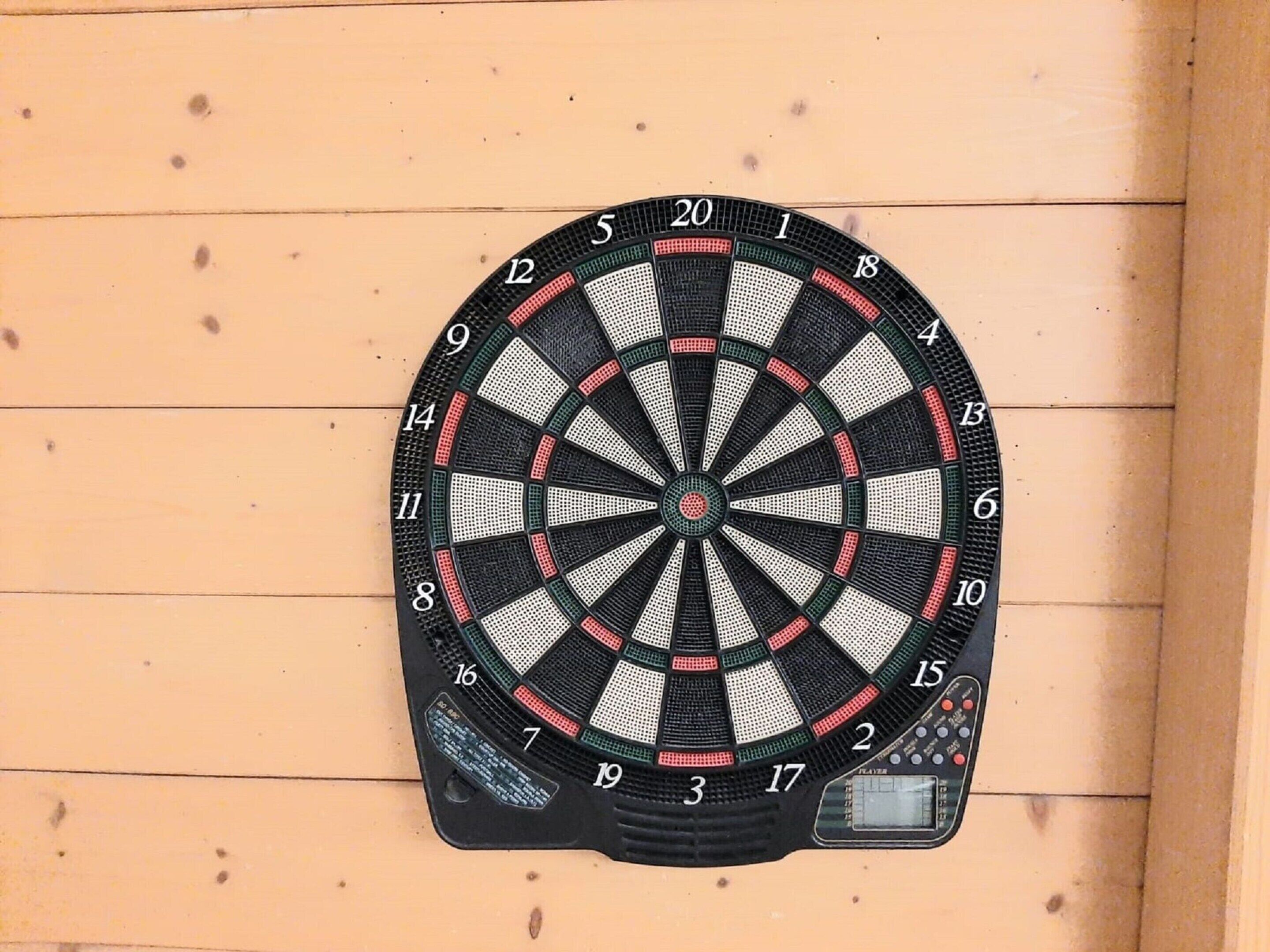 Een dartbord bevestigd aan een houten wand.