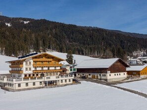 A multi-story hotel with a wooden facade, large balconies, and a ski lift in the background. - Lovely Apartment on a Farm in Radstadt (Radstadt)