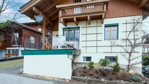 A two-story wooden house with a balcony, a small garden, and a clear sky. - Holiday Apartment in Kaltenbach (Kaltenbach)