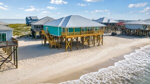 Una propiedad frente al mar con varias construcciones de madera elevadas sobre pilotes, unidas por pasarelas.