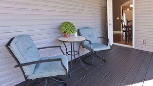 A covered outdoor seating area with two chairs and a table, a potted plant, and a door leading to an interior space. - Lakes at Standifer Gap - Small subdivision close to Hamilton area, best shopping (Chattanooga)