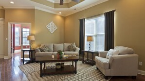 A living room with a beige sofa, a coffee table, and a patterned rug. - Lakes at Standifer Gap - Small subdivision close to Hamilton area, best shopping (Chattanooga)