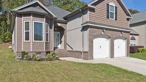 A two-story house with a brick facade, a front porch, and two garage doors. - Lakes at Standifer Gap - Small subdivision close to Hamilton area, best shopping (Chattanooga)