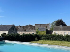 Ein Steinhaus mit einem Pool davor.