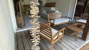 A wooden deck with a spiral staircase leading to a covered area. - Kay Agapi - on the beach - Diamant (Le Diamant)