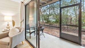 A modern interior with a glass door leading to an outdoor area with a view of trees. - Luxury Townhouse in Santa Rosa Beach - The Zen Pad (Santa Rosa Beach)