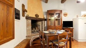 Un comedor acogedor con chimenea de ladrillo, mobiliario de madera y televisor.