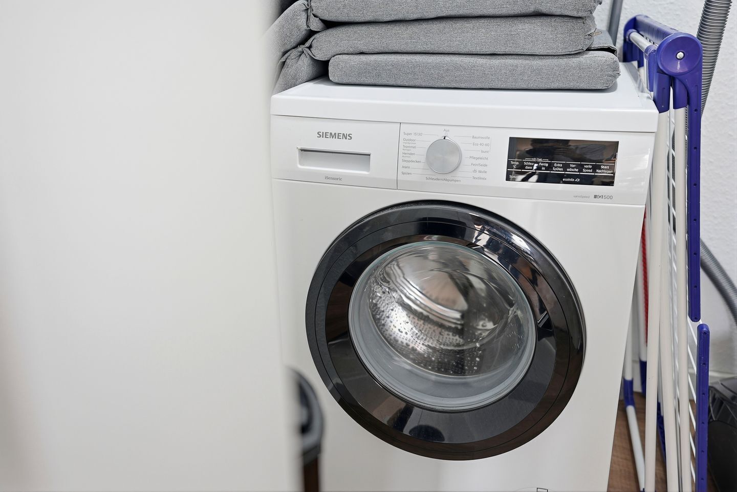A white Siemens washing machine with a control panel and a transparent door.