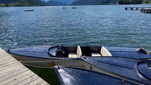 A lake with boats docked at a wooden pier. - Holiday Home Bodensdorf Near Gerlitzen Ski Area (Steindorf am Ossiacher See)