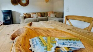A dining area with a wooden table, a chandelier, and a sofa in the background. - Cozy Holiday Home in Nieuwpoort With Swimming Pool (Nieuwpoort)