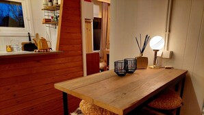 A wooden dining table with two black candle holders and a lamp. - Tranquil Chalet in Geel With Garden (Geel)