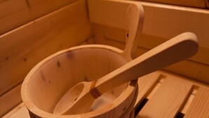 A wooden bowl with a wooden spoon inside, placed on a wooden surface.